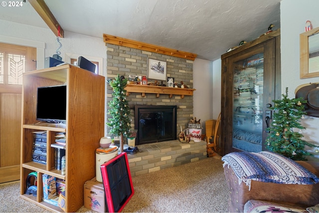 carpeted living room with a textured ceiling, brick wall, and a fireplace