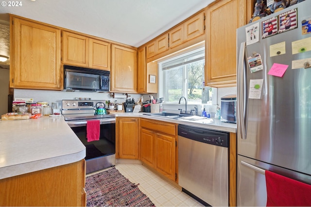 kitchen with sink, light tile flooring, and stainless steel appliances