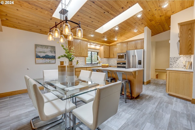 tiled dining area featuring wood ceiling, vaulted ceiling with skylight, sink, and a chandelier