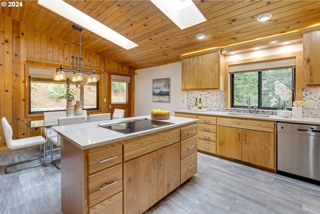 kitchen with vaulted ceiling with skylight, stainless steel dishwasher, hanging light fixtures, sink, and plenty of natural light