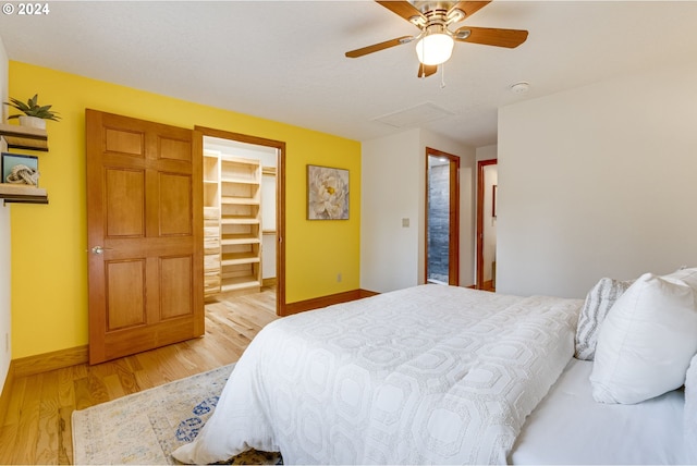 bedroom featuring a closet, light hardwood / wood-style floors, a spacious closet, and ceiling fan