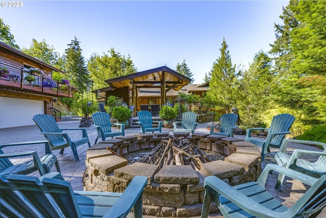 view of patio / terrace featuring an outdoor fire pit and a balcony