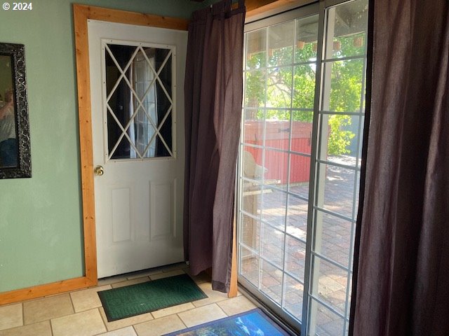 doorway to outside with light tile patterned floors