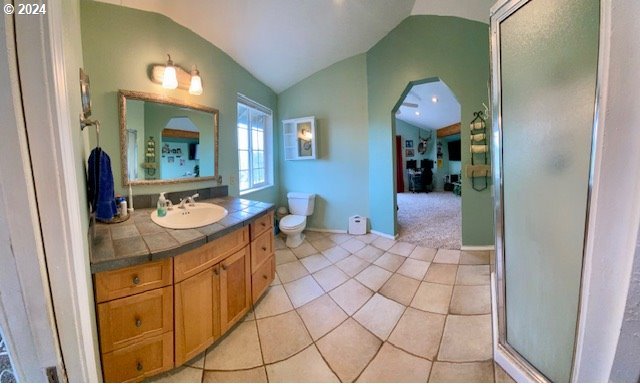 bathroom featuring tile patterned flooring, vaulted ceiling, vanity, and toilet