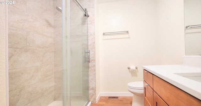 bathroom with walk in shower, vanity, wood-type flooring, and toilet