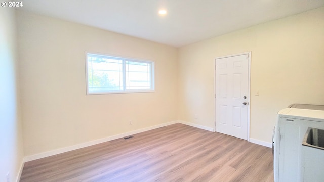 laundry room featuring separate washer and dryer and light hardwood / wood-style flooring