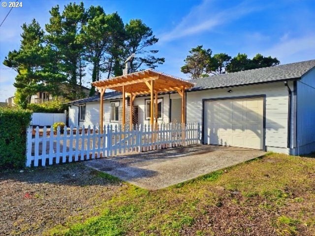 view of front of home with a garage and a pergola