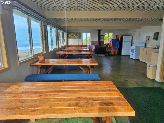 dining area with a wood stove, a wealth of natural light, and concrete floors