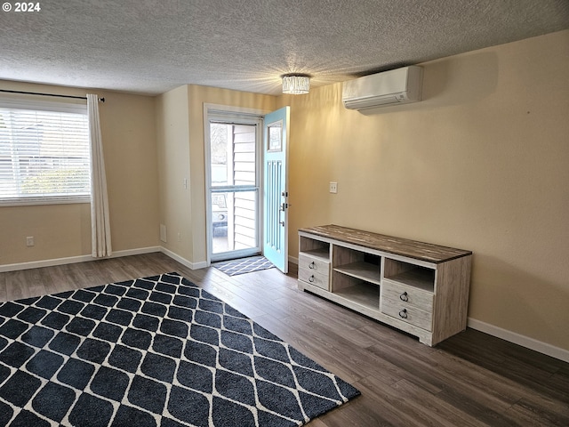 entryway featuring wood-type flooring, a textured ceiling, and an AC wall unit