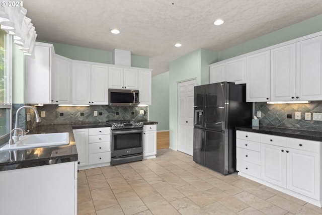 kitchen with backsplash, white cabinetry, sink, and stainless steel appliances