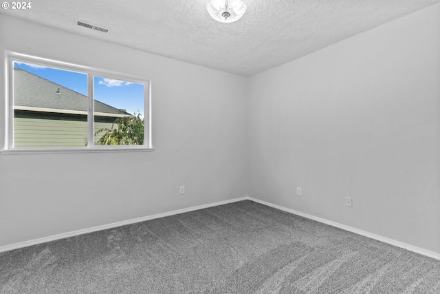 spare room featuring carpet flooring and a textured ceiling