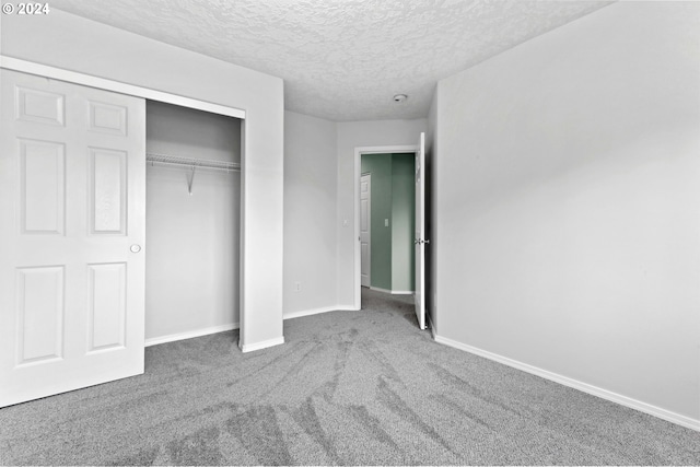 unfurnished bedroom with carpet, a textured ceiling, and a closet