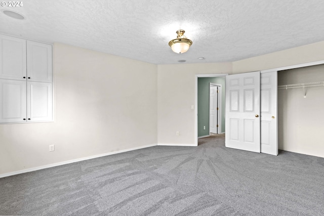 unfurnished bedroom with dark colored carpet, a textured ceiling, and a closet