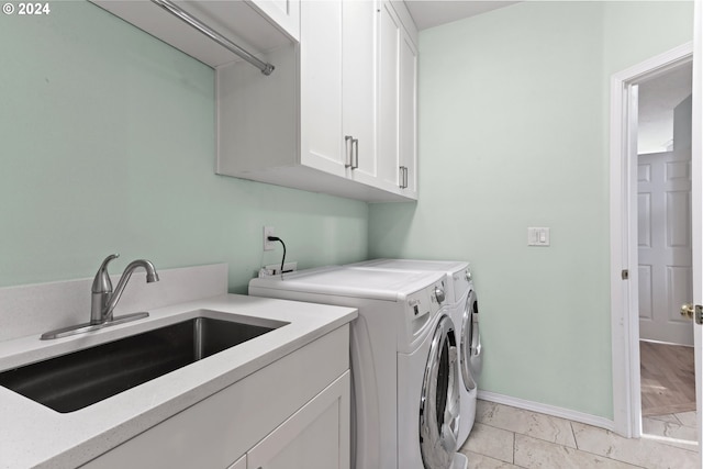 laundry room featuring cabinets, washer and clothes dryer, and sink