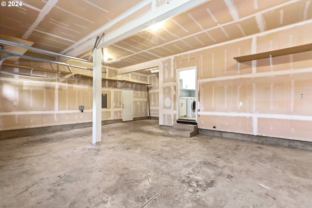 garage featuring electric panel and washer / clothes dryer