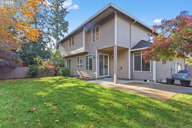 back of house with a lawn and a patio