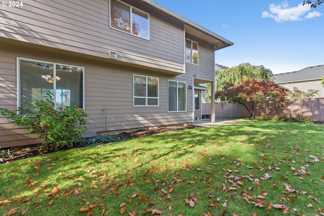 back of property with a yard and a patio