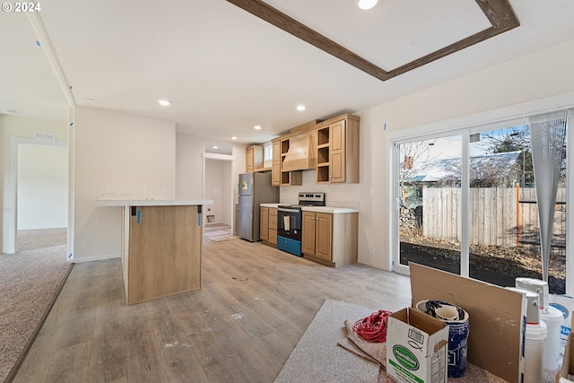 kitchen featuring stainless steel appliances, a kitchen breakfast bar, light hardwood / wood-style flooring, premium range hood, and a kitchen island