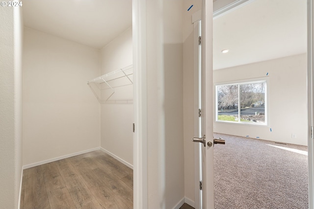 walk in closet with light hardwood / wood-style flooring