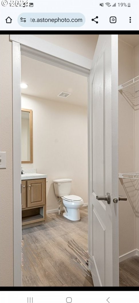 bathroom with hardwood / wood-style flooring, vanity, and toilet