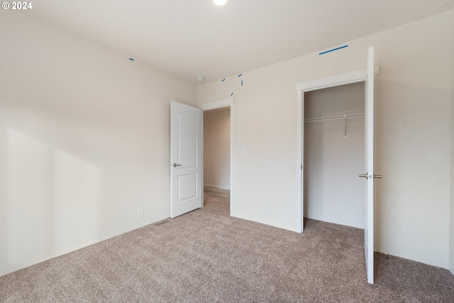 unfurnished bedroom with carpet and a closet