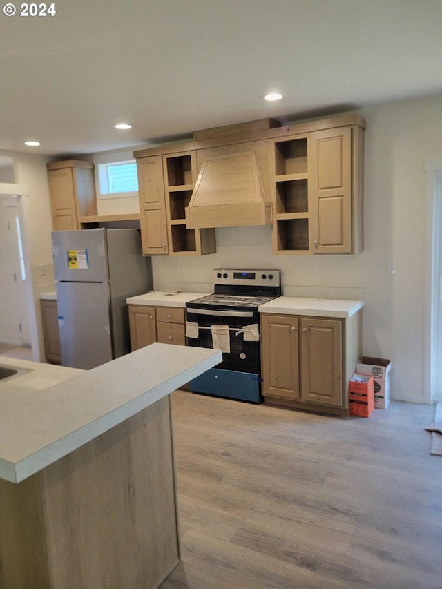 kitchen with premium range hood, light brown cabinets, electric range, light hardwood / wood-style flooring, and fridge