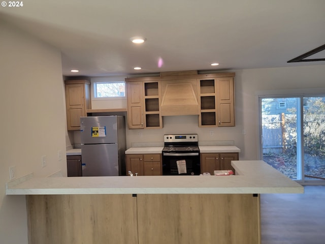 kitchen with a breakfast bar area, custom range hood, light brown cabinetry, kitchen peninsula, and stainless steel appliances