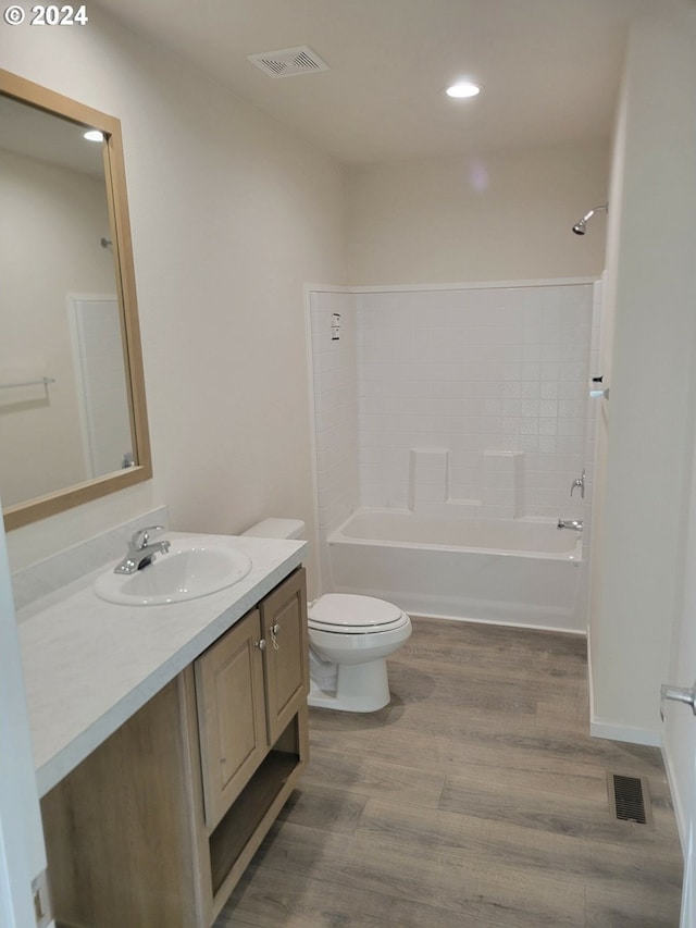 full bathroom with vanity, toilet, wood-type flooring, and shower / tub combination