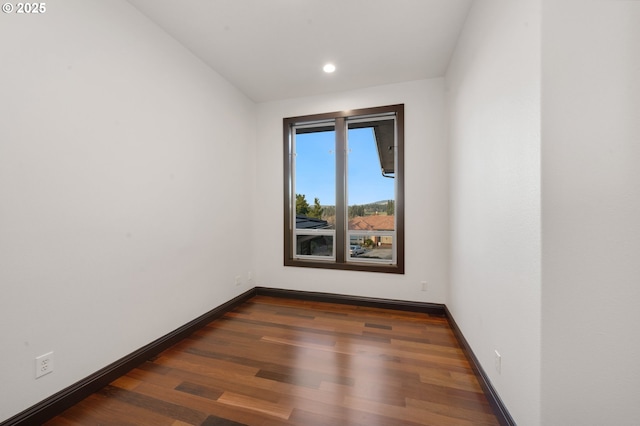 unfurnished room with dark wood-type flooring