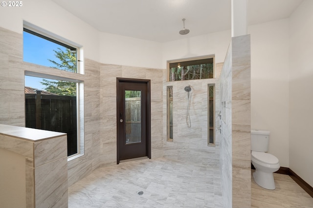 bathroom featuring a tile shower and toilet