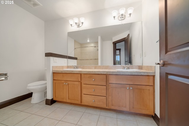 bathroom featuring tile patterned floors, toilet, vanity, and tiled shower