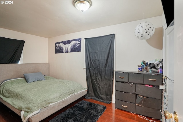 bedroom with dark hardwood / wood-style flooring