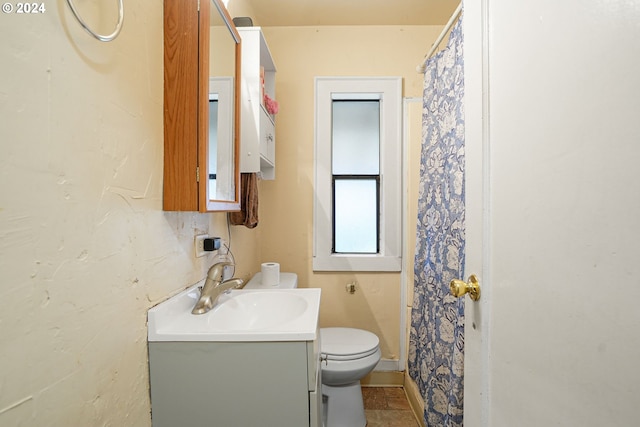 bathroom with tile patterned floors, vanity, toilet, and walk in shower