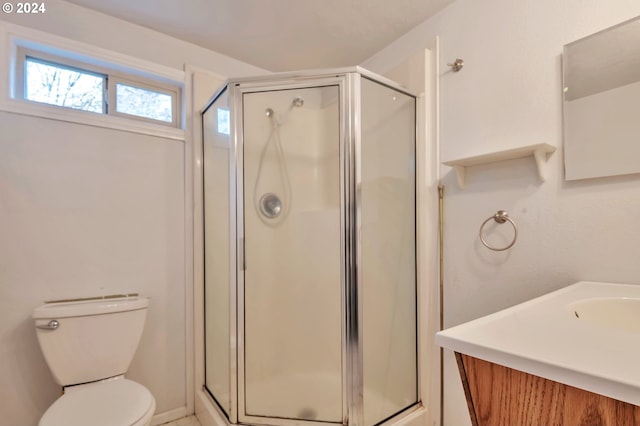 bathroom with an enclosed shower, vanity, and toilet