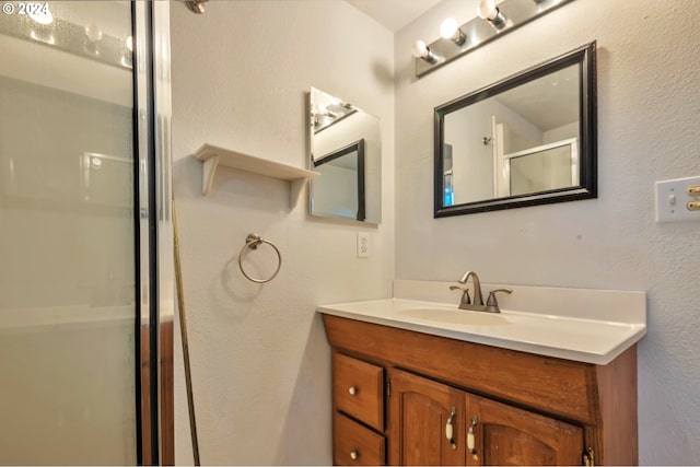 bathroom featuring vanity and a shower with door