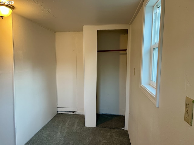 interior space with a closet and dark colored carpet