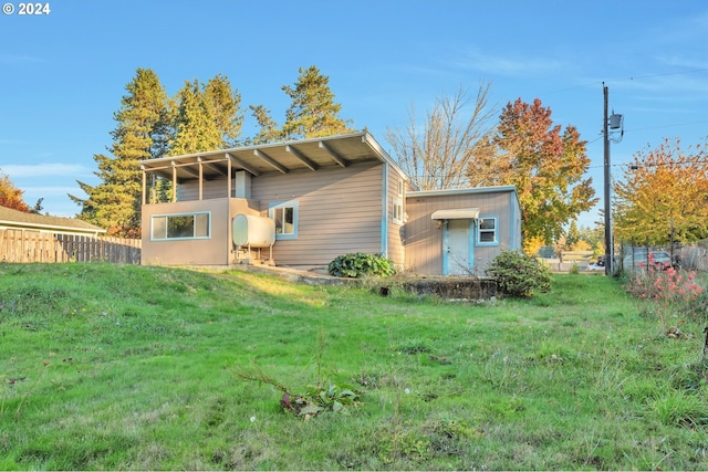 rear view of house featuring a yard