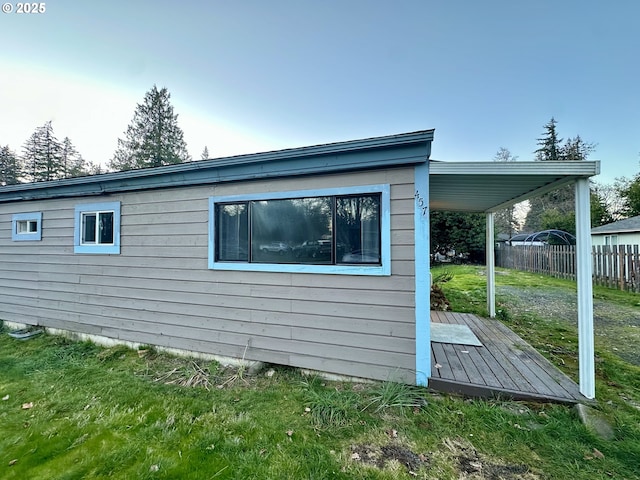 view of property exterior with a wooden deck and a yard