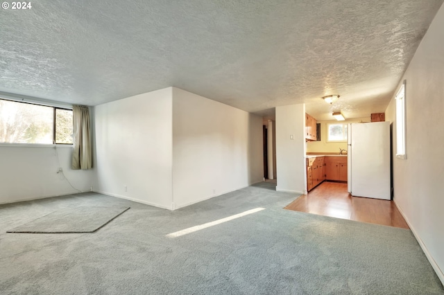 carpeted empty room with a textured ceiling