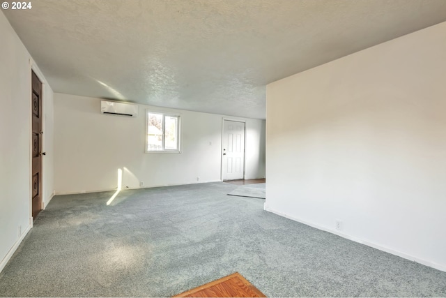 spare room with a textured ceiling and a wall unit AC