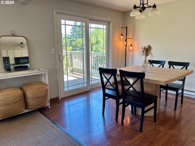 dining area featuring dark hardwood / wood-style flooring and an inviting chandelier