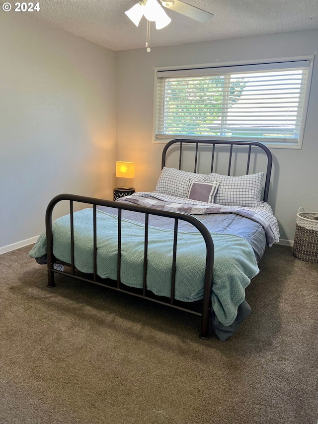 carpeted bedroom with a textured ceiling and ceiling fan