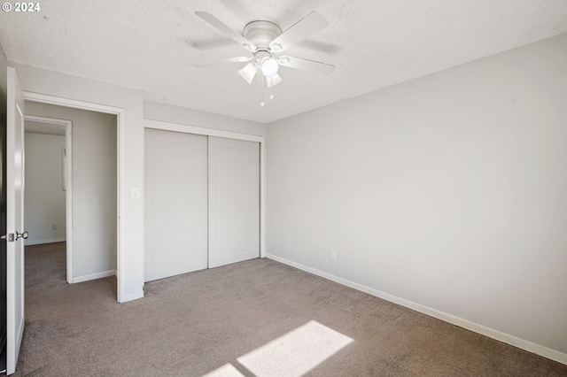 unfurnished bedroom featuring carpet flooring, a textured ceiling, a closet, and ceiling fan