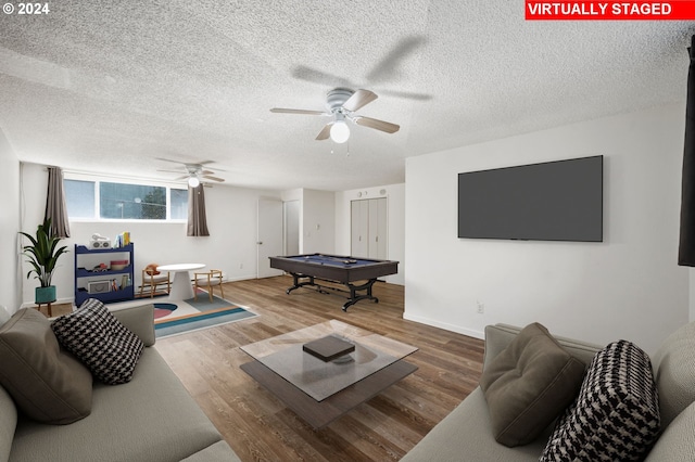 living room featuring a textured ceiling, wood-type flooring, and pool table