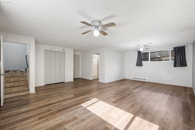 unfurnished living room featuring ceiling fan, a textured ceiling, hardwood / wood-style flooring, and a baseboard heating unit