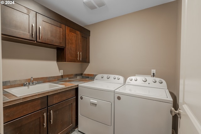 laundry area featuring cabinets, sink, and washing machine and clothes dryer