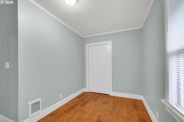 spare room with wood-type flooring and ornamental molding