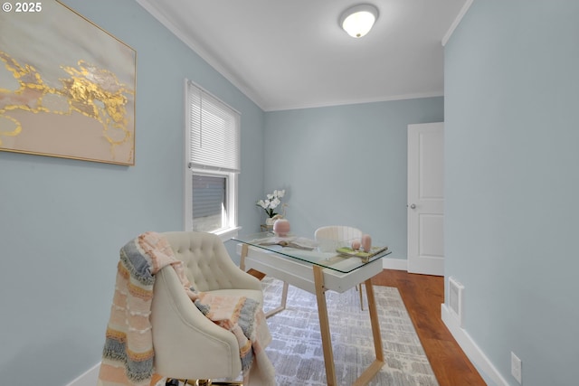 office featuring baseboards, crown molding, wood finished floors, and visible vents