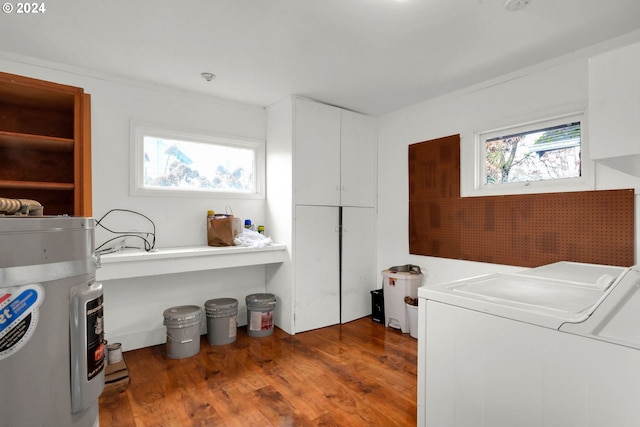 laundry room with cabinets, electric water heater, crown molding, hardwood / wood-style flooring, and washing machine and dryer