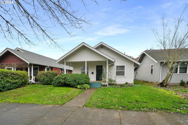 bungalow-style home with covered porch and a front yard